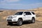 Toyota 4runner SUV in desert road with blue sky. 4wd SUV car road canyon desert. Outdoor landscape. Travel in Kazakhstan concept.