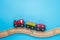 Toys background with copy space. Kids toy train with two carriages on wooden railway  on blue background with copy space for text