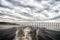 Trace of speed boat on blue sea water in manaus, brazil. Seascape with bridge on horizon on cloudy sky. travelling and vacation. a