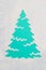 A trace from a stencil in the shape of a Christmas tree made of flour on a blue background. Ideas for festive baking and decoratin