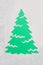 A trace from a stencil in the shape of a Christmas tree made of flour on a green background. Ideas for festive baking and decorati