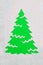 A trace from a stencil in the shape of a Christmas tree made of flour on a green background. Ideas for festive baking and decorati