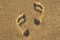 Traces of feet on the beach yellow sand. Footprints on the beach