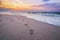 Traces of the person on sea beach, sunrise