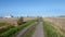 Track through fields with industry in background