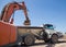 Tracked excavator and an articulated construction dumper during excavation in a sand pit on a hot sunny day