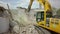 Tracked excavator demolishing old buildings, aerial view