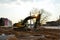 Tracked excavator working at a construction site during laying or replacement of underground storm sewer pipes.