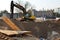 Tracked excavator working at a construction site during laying or replacement of underground storm sewer pipes.