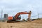 Tracked excavator working at a construction site during laying or replacement of underground storm sewer pipes.