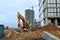 Tracked excavator working at a construction site during laying or replacement of underground storm sewer pipes.