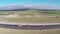 Tracked paver laying fresh asphalt pavement on an airport runway, aerial view