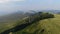 Tracking Aerial View of Paragliding Pacarhute Flying Above Green Mountain Hills