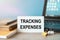 TRACKING EXPENSES - an inscription on a card near office supplies