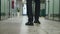 Tracking of legs of businessman in formal suit walking along office corridor. Rear back view feet of unrecognizable male