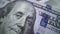 Tracking macro of Benjamine Franklin`s face on the US one hundreed dollar bill. US dollars background