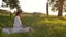 Tracking shot of attractive young woman in straw hat typing on laptop looking on display screen sitting on field with