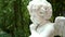 Tracking shot of beautiful green garden with statue of white angel. home decorating and garden design concept