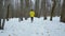 Tracking shot of male sports man running on snow in winter forest