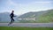 Tracking shot: woman legs in sports shoes in detail running near lake and mountains. Girl training jogging in park early morning.