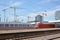 Tracks and platforms of Mannheim main train station with German `IC Intercity` train passing through on summer day with blue sky