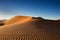 Tracks of wind on an orange sand dune