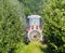 Tractor with an agricultural sprayer machine with large fan, spreads pesticides in an apple orchard