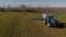 Tractor applying liquid mineral fertilizers to the soil on winter wheat