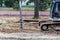 A tractor with an auger for drilling the soil when performing earthworks for the reconstruction of a city road.