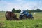 Tractor bale hay in field, blue tractor to collect hay in bales