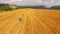Tractor Baler Driving Along Yellow Wheat Field