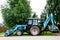 Tractor bulldozer with different buckets, shovels on rustic background