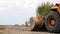 Tractor bulldozer drives extremely close-up. Low view point. Front-end loader using bucket. Road construction. Large excavator