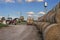 Tractor carrying hay bale rolls - stacking them on pile. Agricultural machine collecting bales of hay on a field