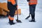 Tractor cleaning the road from the snow. Excavator cleans the streets of large amounts of snow in city. Workers sweep