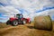 Tractor collecting haystack in the field