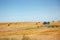 Tractor collecting straw in the field after harvest