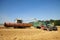 Tractor collecting wheat from a combine harvester . Hertfordshire. UK