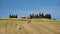 The tractor collects bales with hay in the field