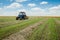 Tractor collects dry hay on the farm field