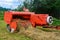 The tractor collects dry hay in the field, the hay presses the bale press, work in the field