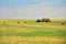 The tractor collects the hay in sheaves and takes it off the field after the mowing of the grain. Agroindustrial industry.