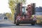 Tractor combine with disc harrows driving along rural road on sunny day. Agricultural machinery and farming concept