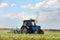 Tractor cultivating field of ripening sunflowers. Agricultural industry