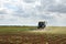 Tractor cultivating field of ripening sunflowers. Agricultural industry