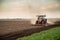 Tractor cultivating field at spring