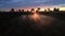 Tractor cultivating field at spring, aerial sunset view