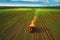 Tractor cultivating field at spring, aerial view