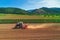 Tractor cultivating the ground in a agricultural field. Cultivate, agriculture and farming concept