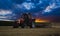 Tractor cultivating wheat stubble field at sunset, crop residue